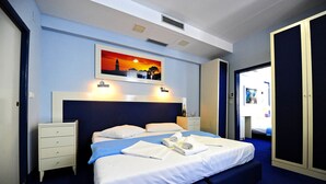 A hotel room with a bed, a nightstand, a painting, and a door. - Jadran-Zvončac Accommodations - Hostel (Split)