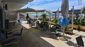 An outdoor patio with tables and chairs, umbrellas, and potted plants. - Jadran-Zvončac Accommodations - Hostel (Split)