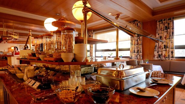 A buffet setup with various food items and serving utensils.