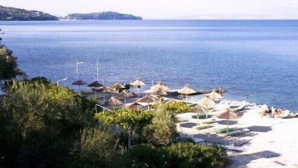 Une plage avec des parasols et une vue dégagée sur la mer.