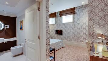 A bathroom with a bidet, a mirror, and a vanity.