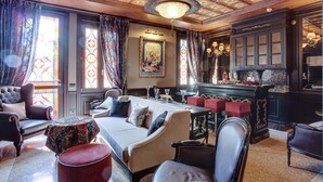 A luxurious hotel room with a large bed, a dining table set for four, a bar area, and a chandelier. - Hotel Moresco (Venice)