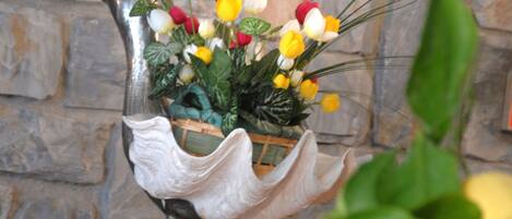 A decorative bird-shaped planter with flowers and a basket.