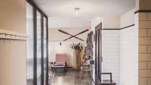Een moderne badkamer met een zwart-wit betegelde vloer, een houten bankje en een grote kamerplant.