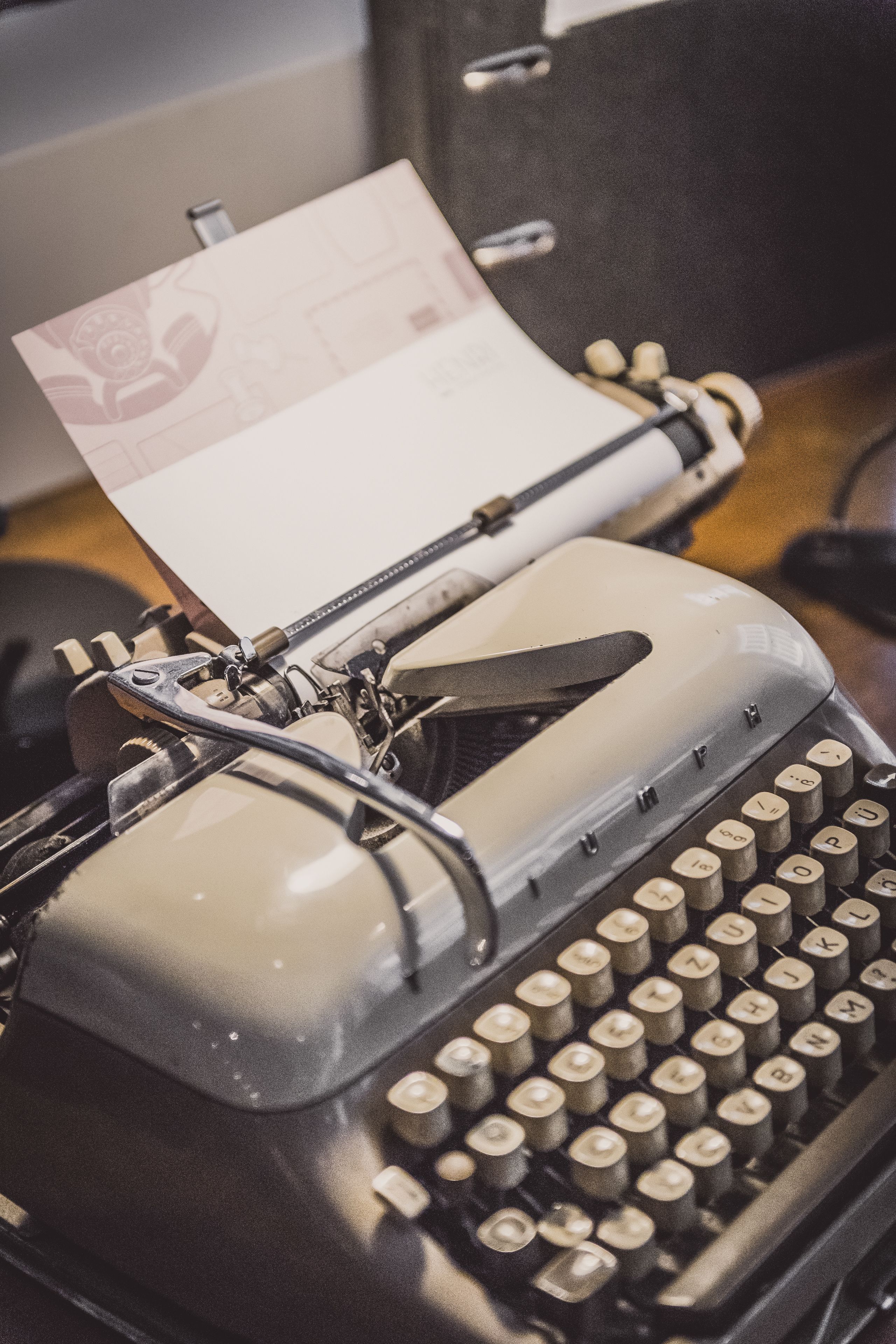 Une machine à écrire ancienne, avec une feuille de papier insérée.