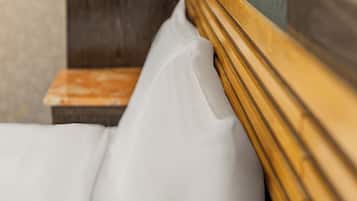 A bed with white bedding and a wooden headboard.