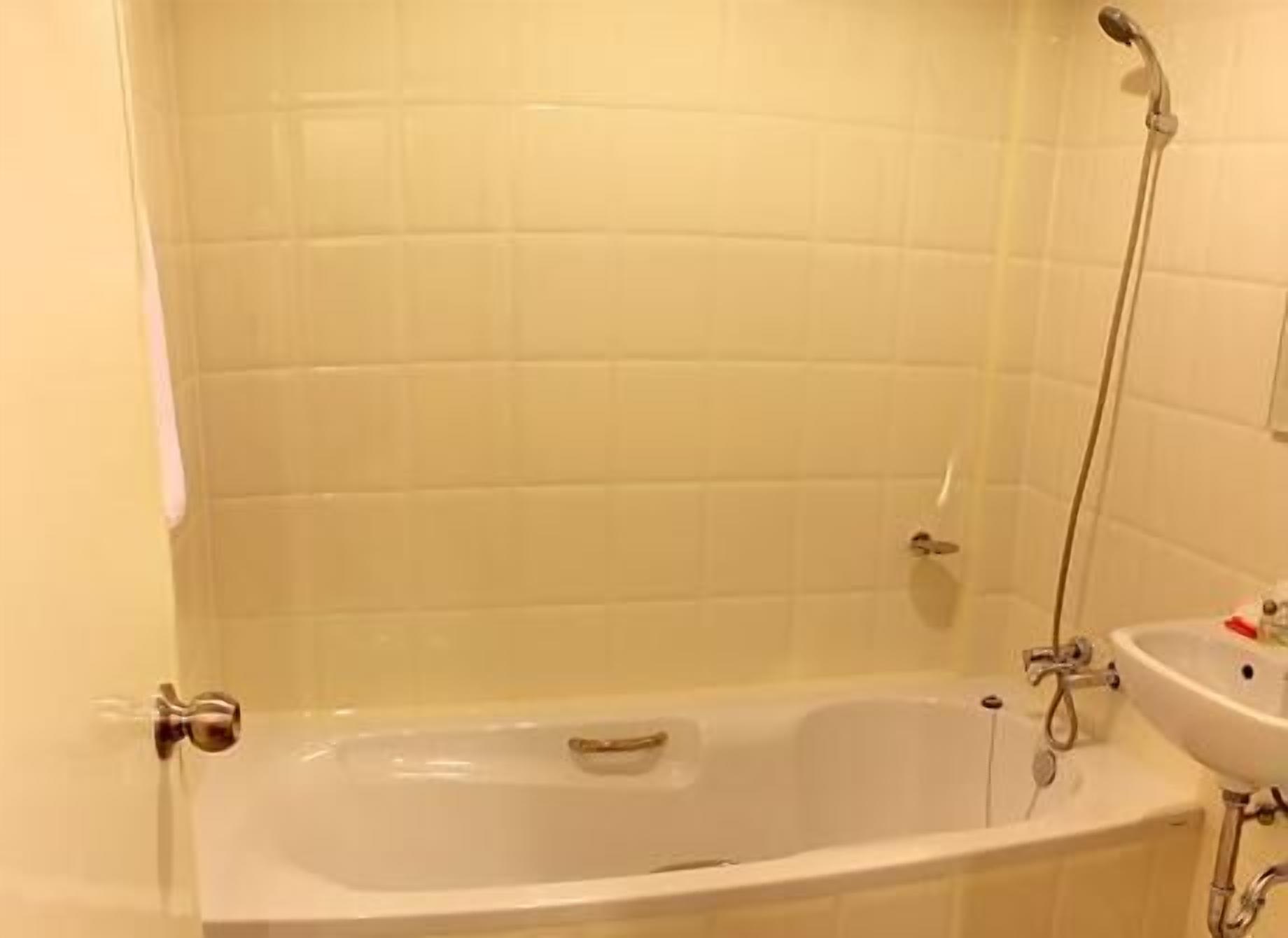 A bathroom with a bathtub, a shower, and a sink.