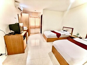 A hotel room with two beds, a desk with a computer, and a shower area. - Cozy Villa (Bangkok)