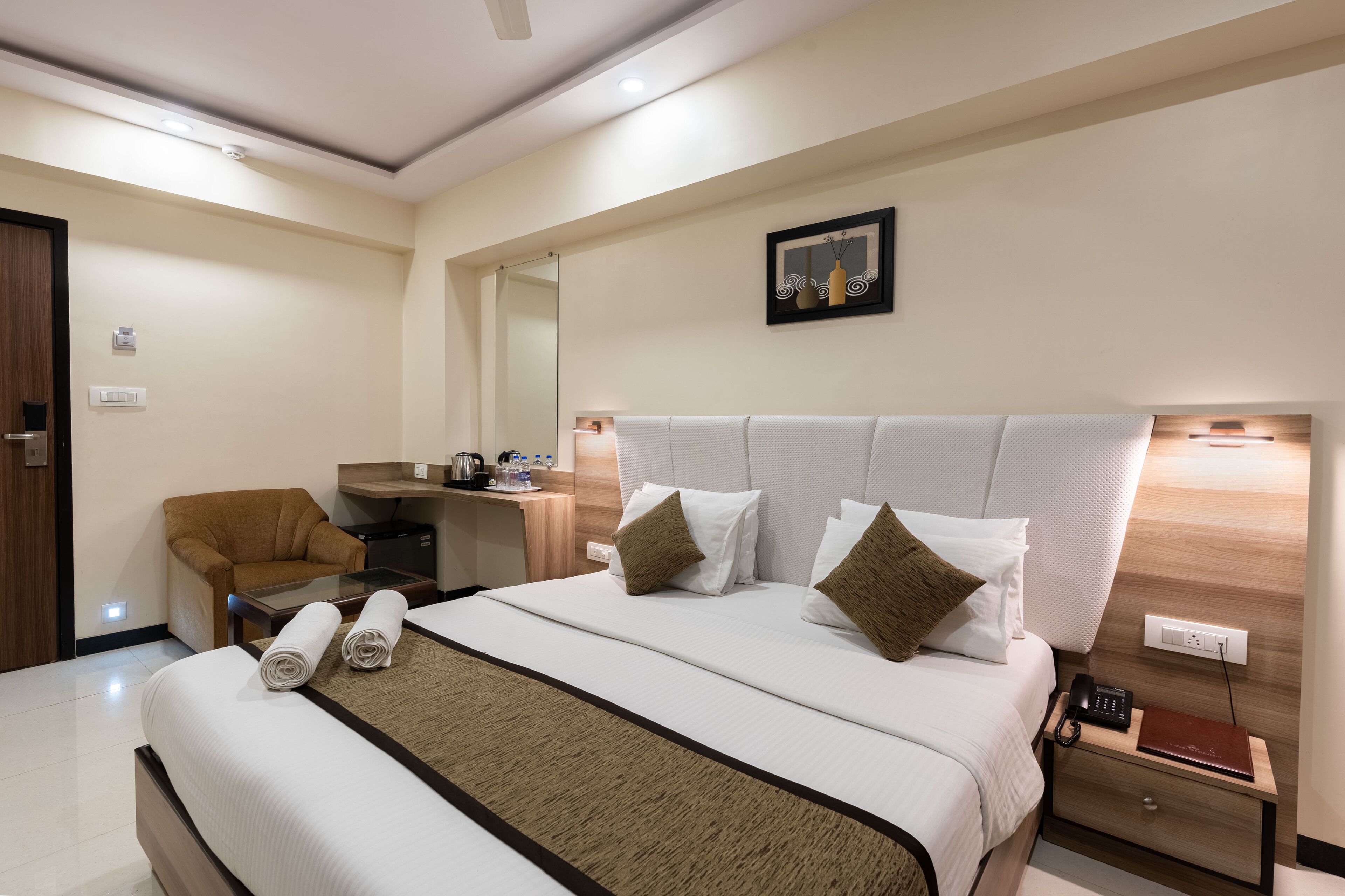 Een hotelkamer met een groot bed, een bureau, een stoel en een kleine tafel.