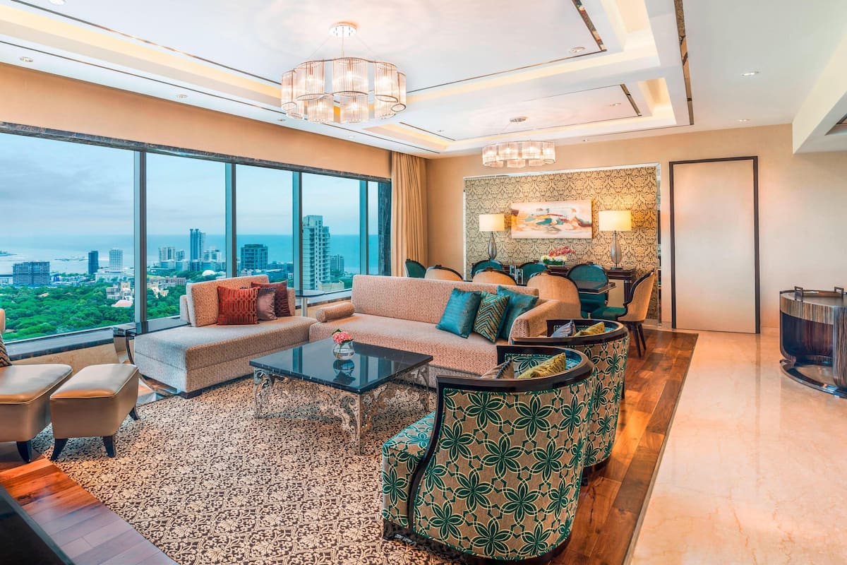 A modern living room with a sofa, chairs, a coffee table, and a patterned rug.