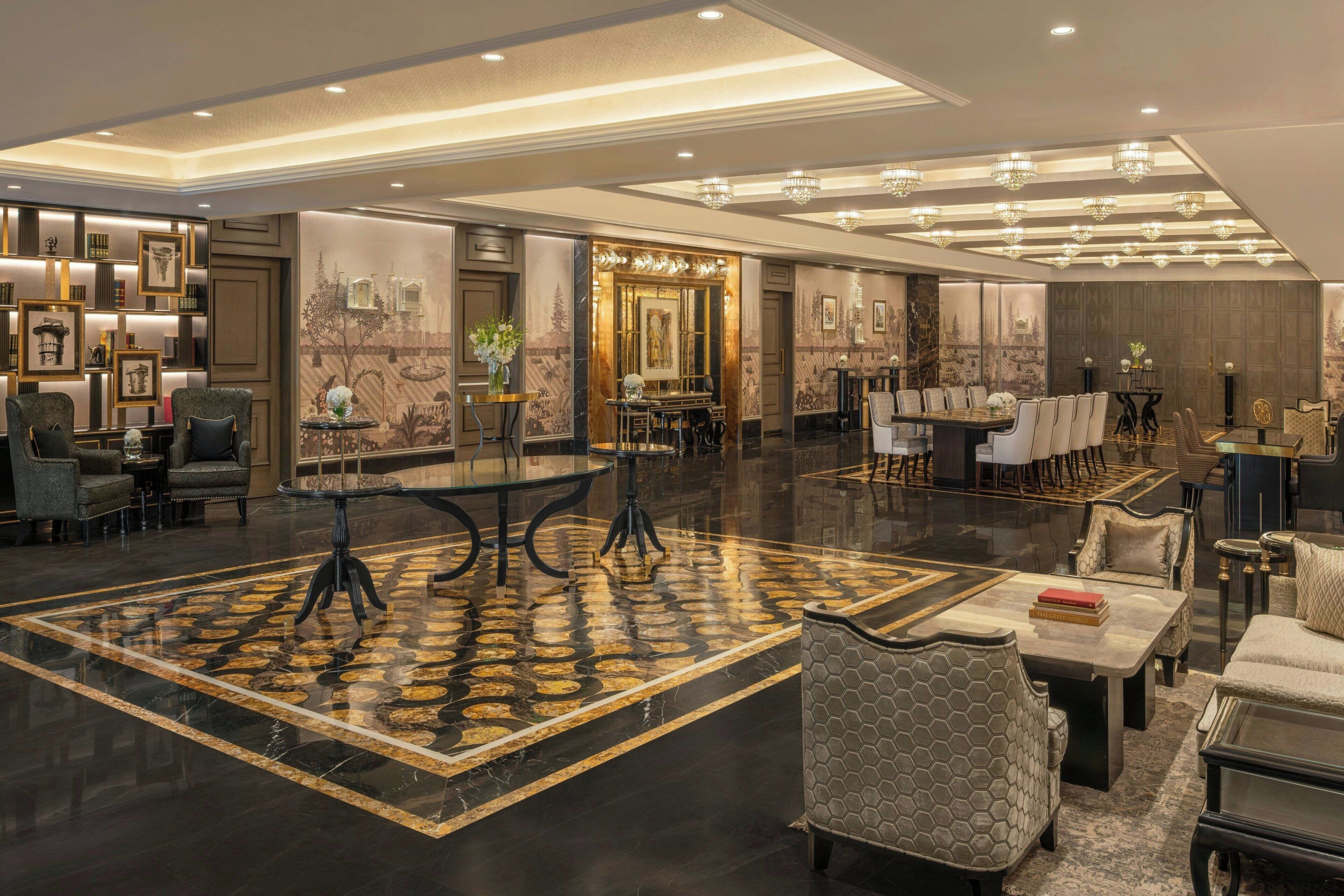 A spacious lobby with a large central area, seating arrangements, and a decorative floor pattern.