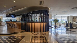 A modern bar area with a curved design, a seating arrangement with bar stools, and a polished floor with geometric patterns. - Istanbul Gonen Hotel (Istanbul)