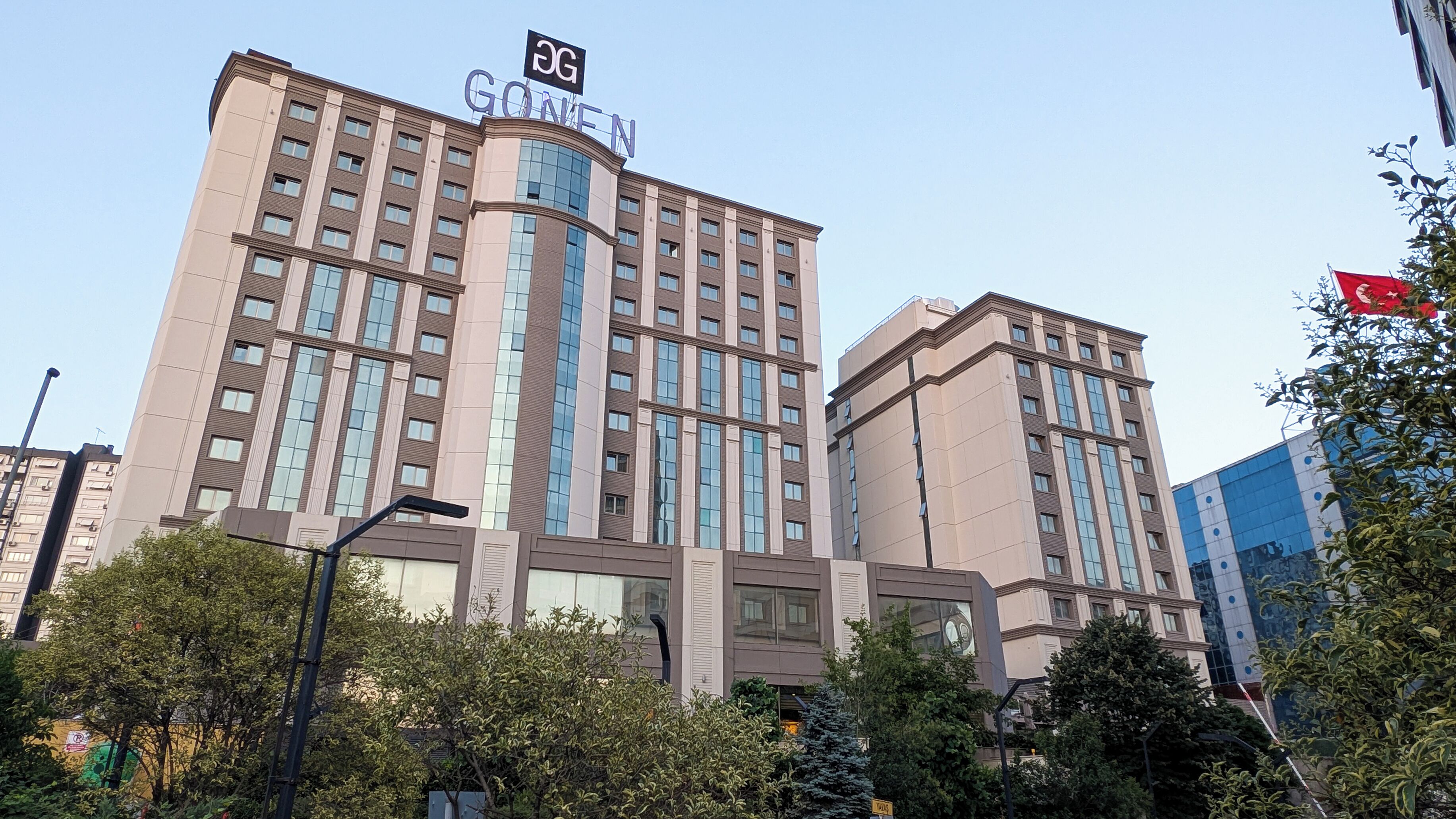 A multi-story hotel with a prominent 'GOVERNMENT' sign, featuring a modern architectural design with large windows and a beige facade.