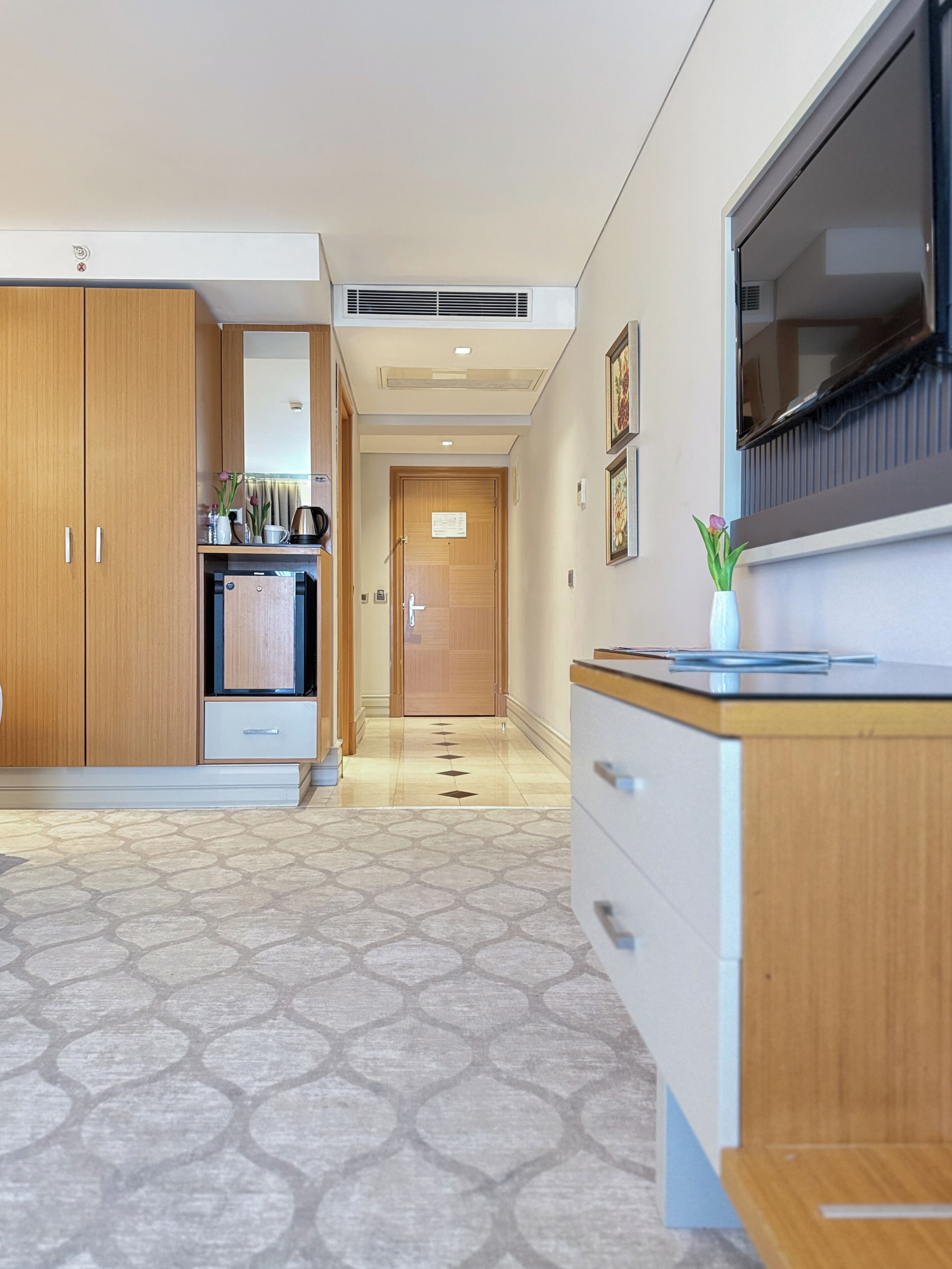 A modern kitchen with wooden cabinets, a built-in oven, and a large window.