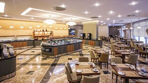 A hotel dining area with buffet counters, seating arrangements, and a modern interior design. - Istanbul Gonen Hotel (Istanbul)