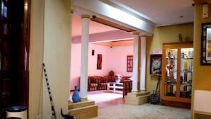 Un salon spacieux avec une cheminée, une table basse et un canapé. Un escalier mène à l’étage supérieur.