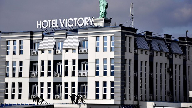 Ein Gebäude mit dem Schild "HOTEL VICTORY" und einer Statue auf dem Dach.