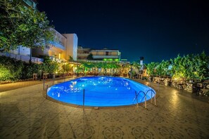 Una piscina al aire libre, tumbonas