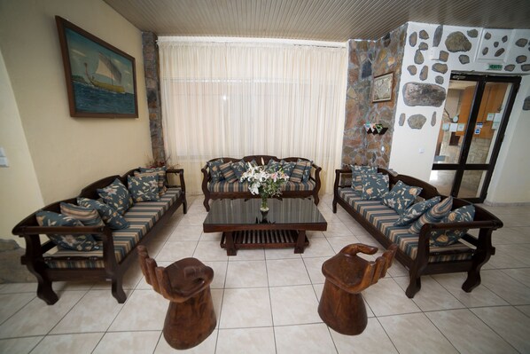 A living room with a sofa set, a coffee table, and two wooden stools.