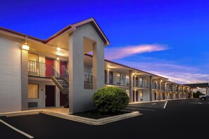 Un motel à étages, doté d’un escalier central et d’une façade bien éclairée.