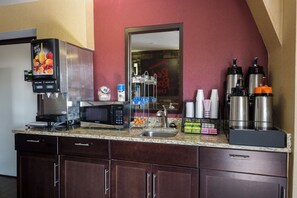A kitchenette with a coffee machine, microwave, and a juice dispenser. - Red Roof Inn Rock Hill (Rock Hill)