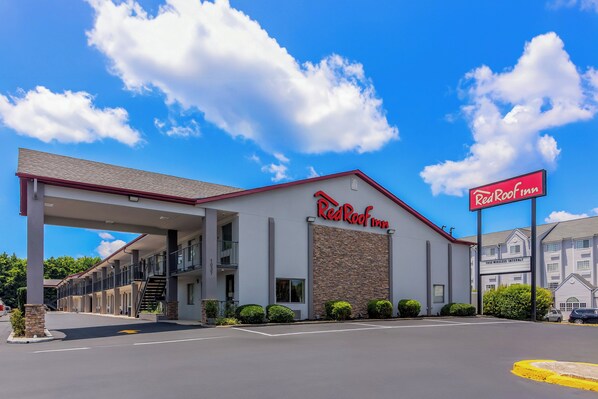 Un hôtel Red Roof Inn doté d’une galerie couverte, d’une façade en pierre et d’une enseigne.