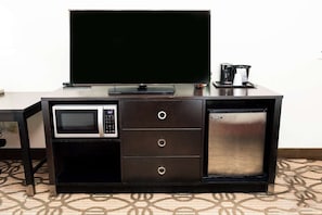 Entertainment unit features a flat-screen TV, microwave, and compact refrigerator.