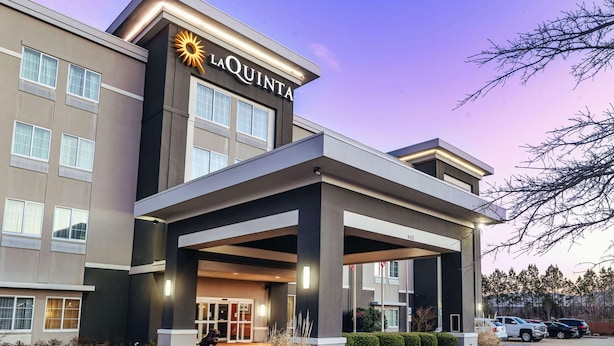 A hotel with a modern facade, a prominent 'La Quinta' sign, and a covered entrance area.