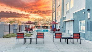 A poolside area with outdoor seating and a view of the pool.