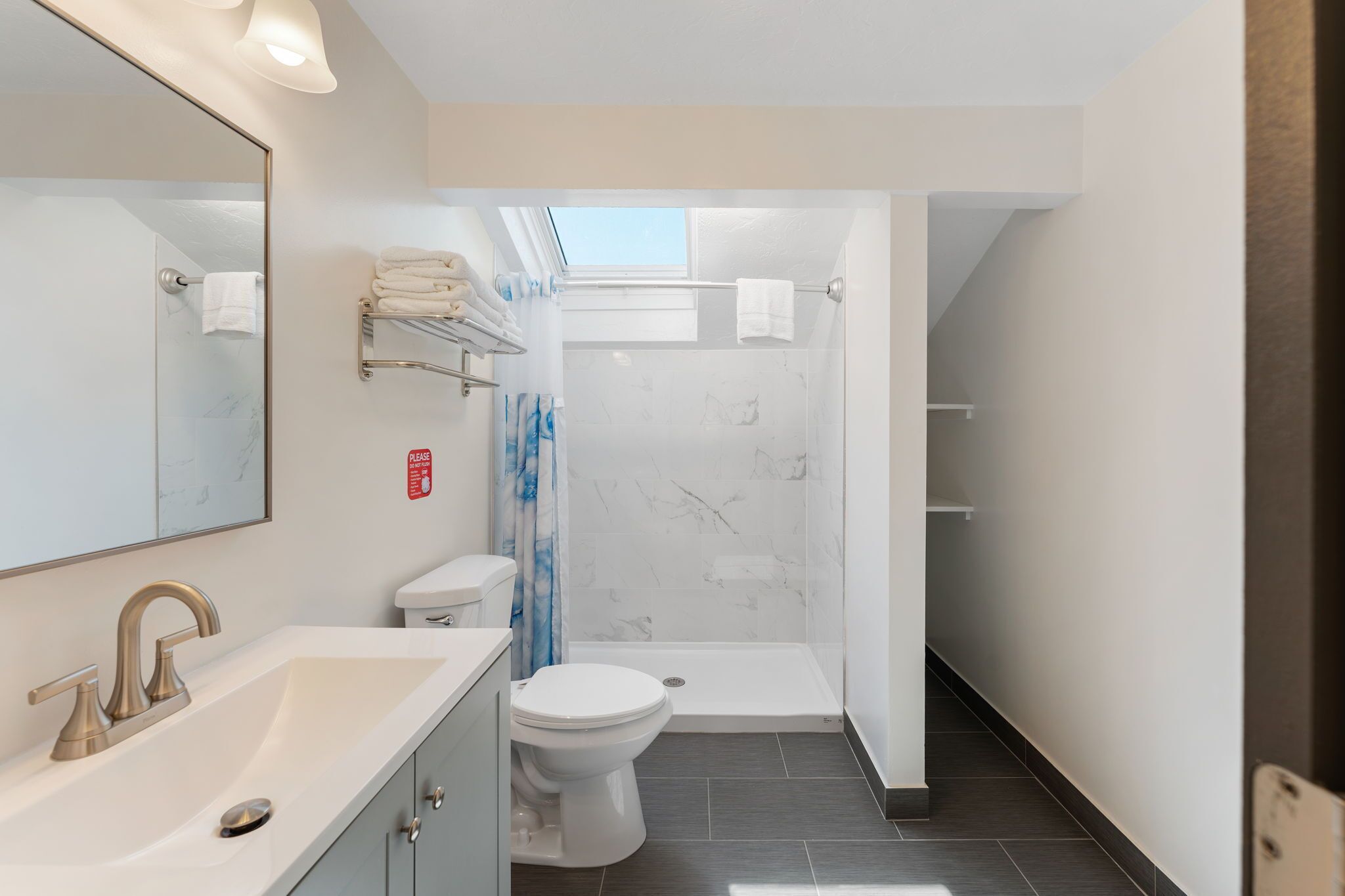 Une salle de bain moderne équipée d’une douche, de toilettes et d’un lavabo.