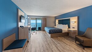 Ein modernes Hotelzimmer mit Bett, Schreibtisch, Stuhl und Meerblick.