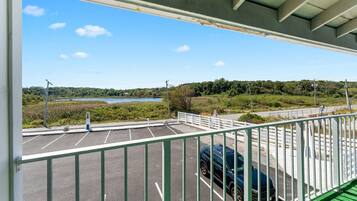 A parking area with a view of a lake and greenery.