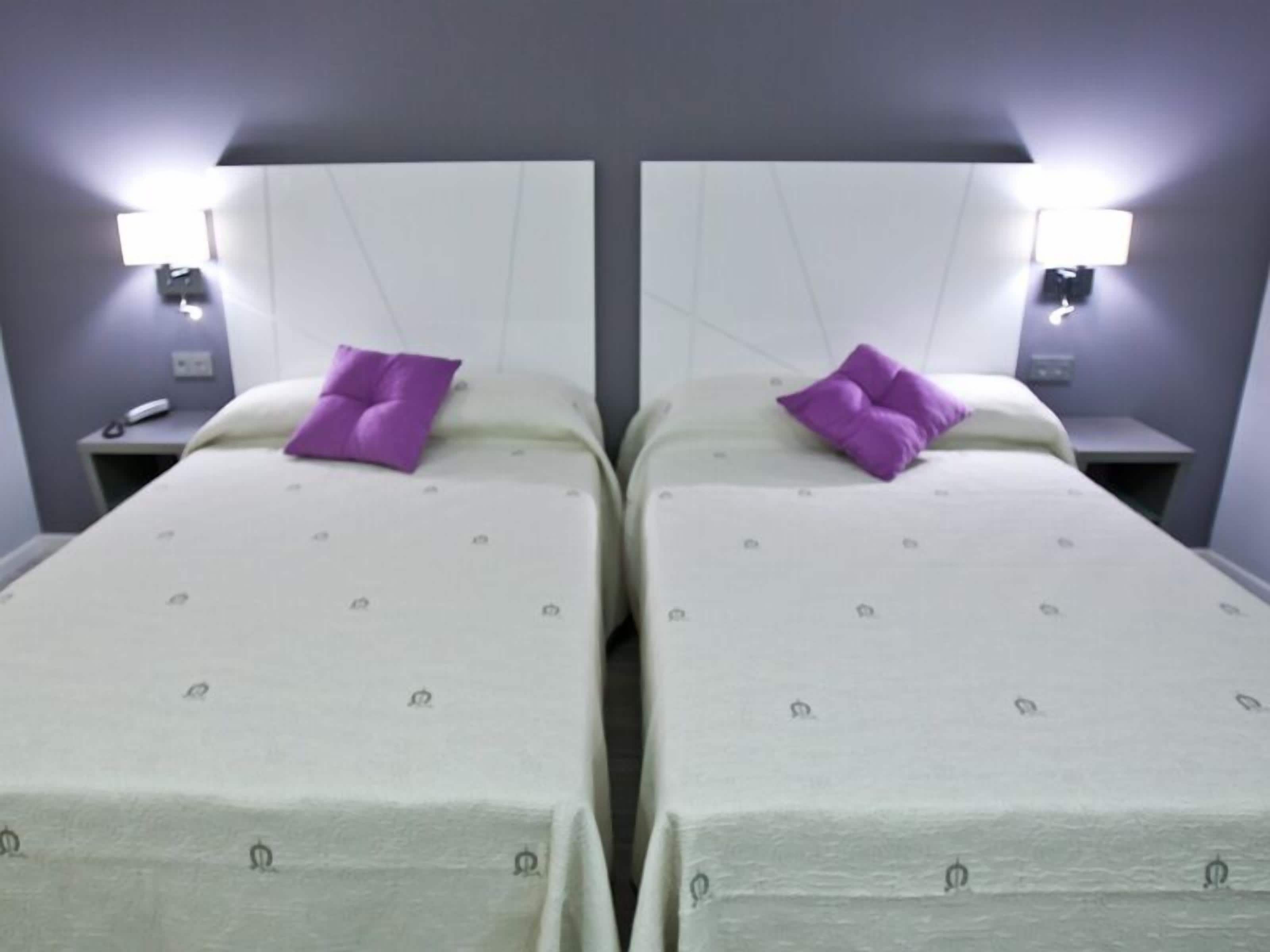 Two twin beds with headboards, each with a nightstand and a lamp.