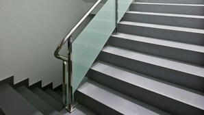 A modern staircase with glass railings and a metal handrail. - Alix Boutique (Arteixo)