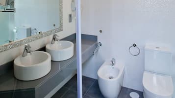Une salle de bain moderne avec deux lavabos, un bidet et des toilettes.