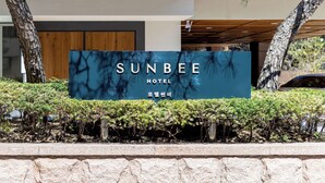 En hotellskylt med namnet ”SUNBEE HOTEL” och koreanska tecken.