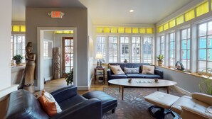 A spacious lobby with a sofa, chairs, a coffee table, and a statue.