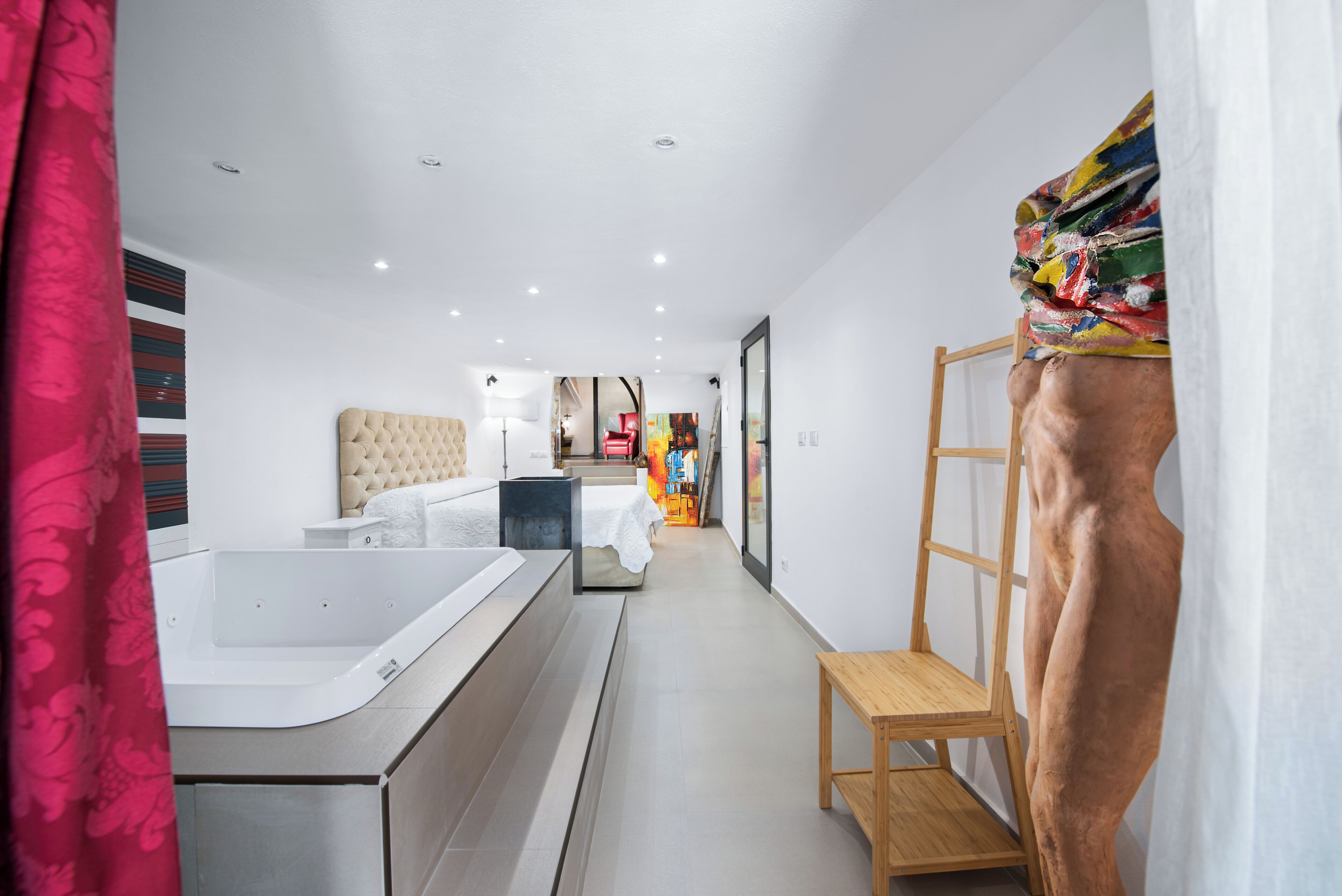 Un bagno moderno con una vasca da bagno spaziosa, una panca di legno e un angolo doccia.