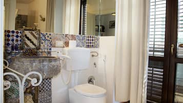 A bathroom with a toilet, sink, and shower.