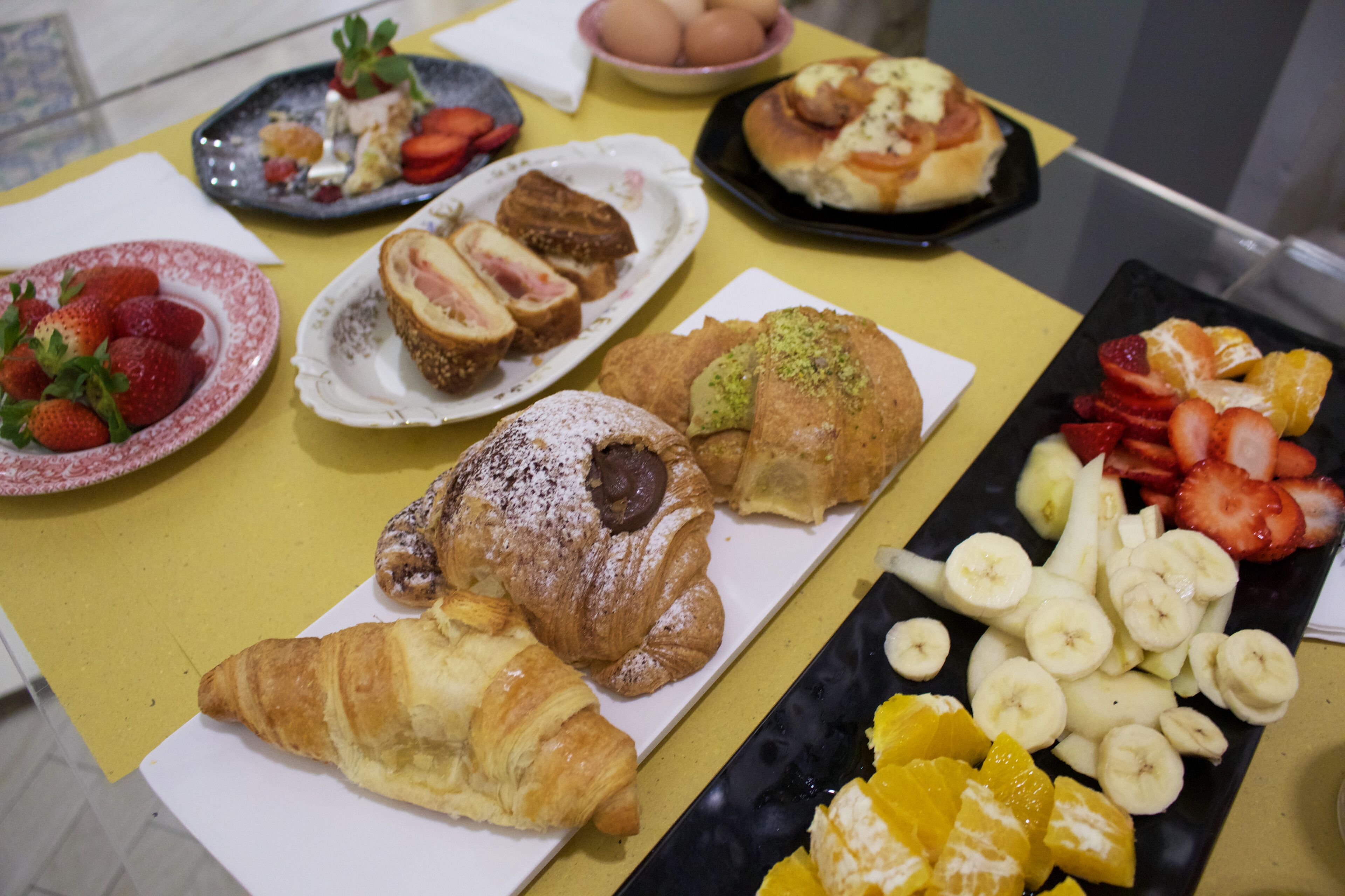 Una mesa con diversos pasteles y frutas.