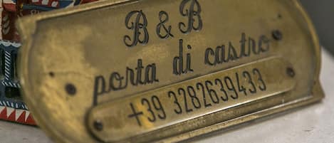 Una placa de latón con texto grabado y un número de teléfono.