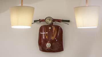 Una Vespa 50 antigua montada en una pared con dos lámparas colgantes.
