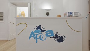 A room with a white wall, a door, and a shelf with books and a small decorative item. - Afea Art & Rooms (Palermo)