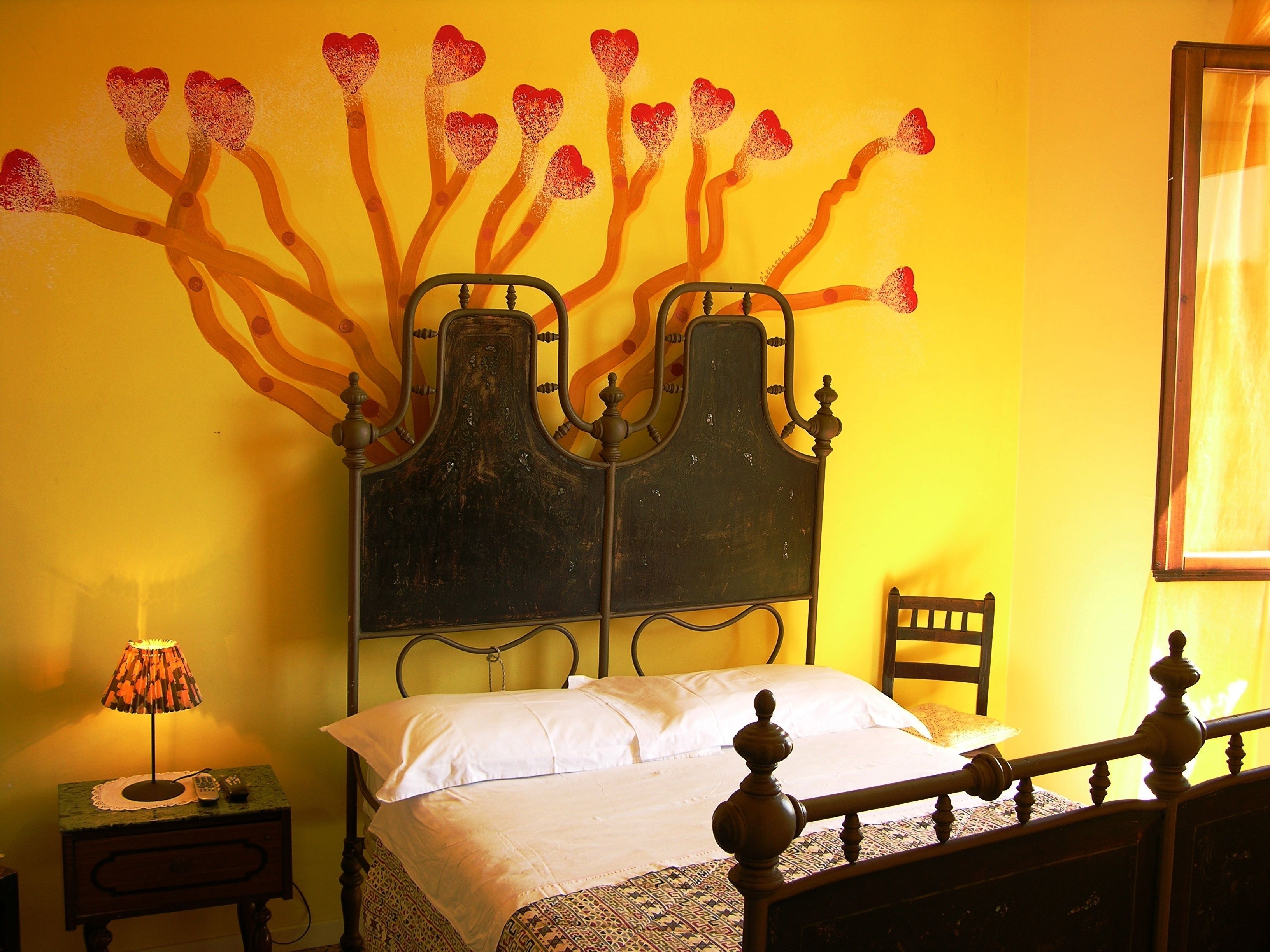 A bed with a headboard, a bedside table with a lamp, and a chair.