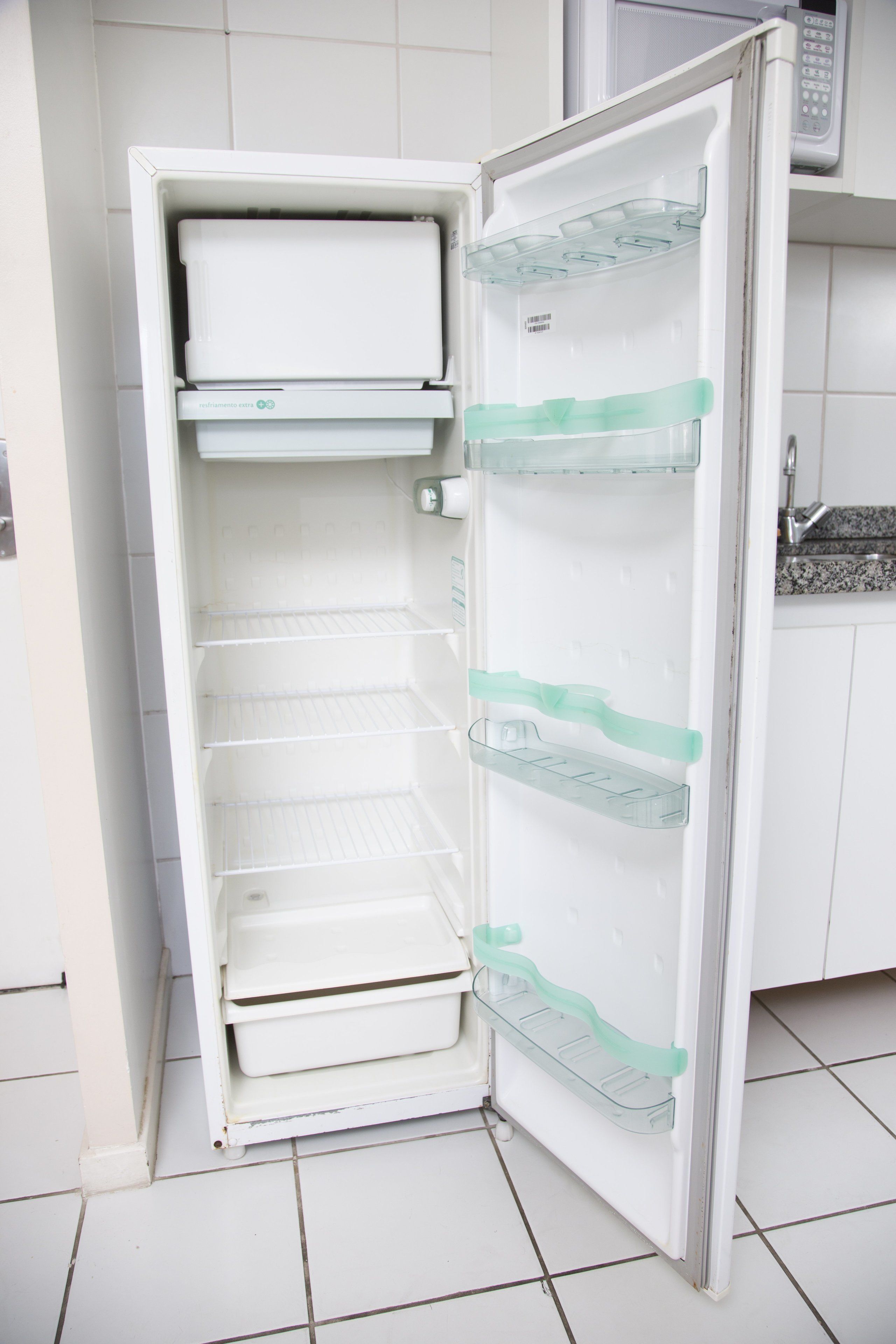 Un refrigerador abierto con estantes y un compartimento congelador.