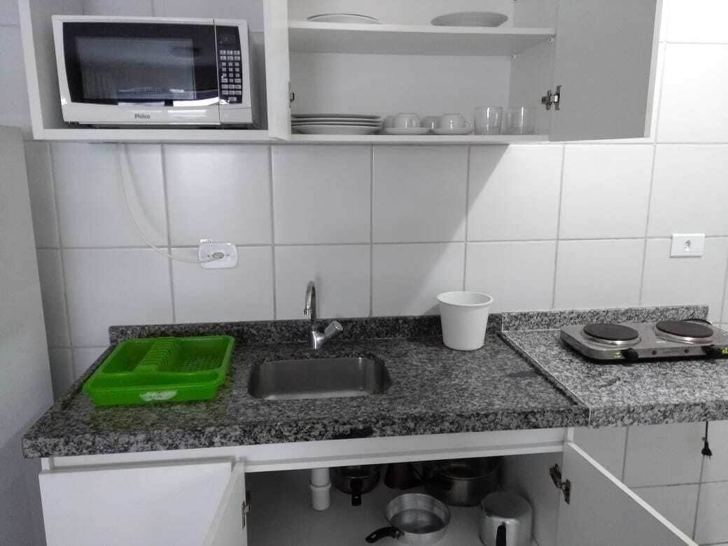 A kitchen with a microwave, sink, and stove.