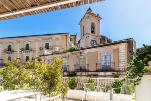 Una terrazza con posti a sedere all'aperto, una torre dell'orologio e architettura classica.