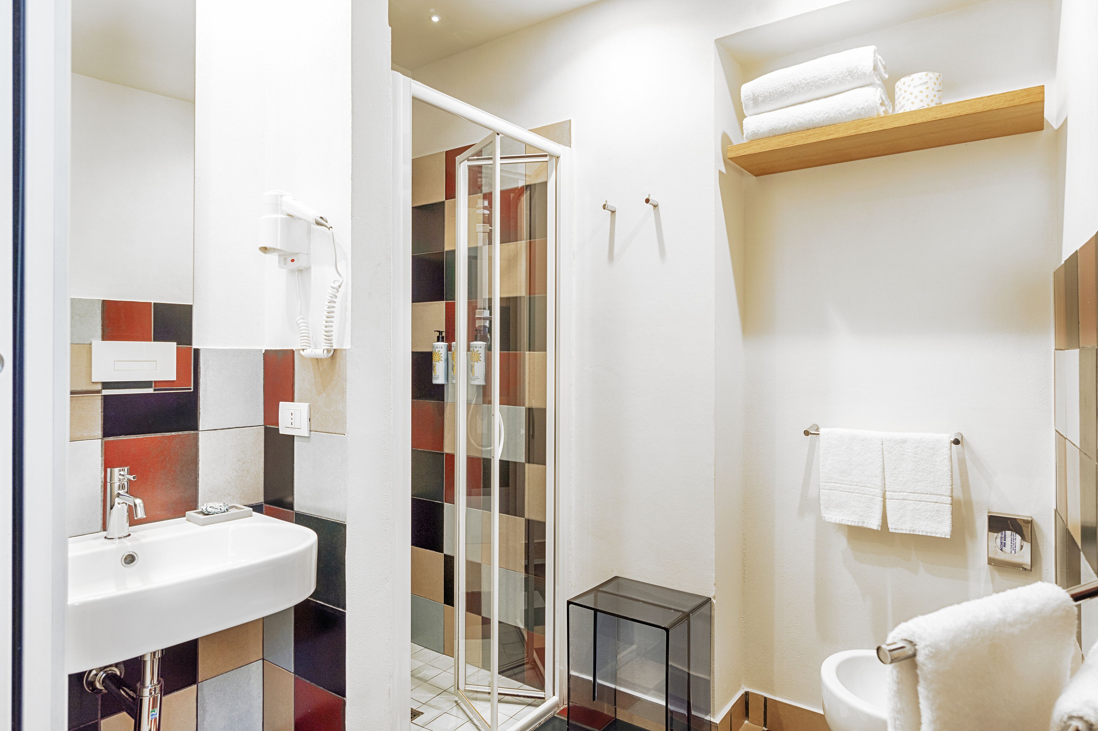 Ein modernes Badezimmer mit Duschkabine aus Glas, Waschbecken und Toilette.