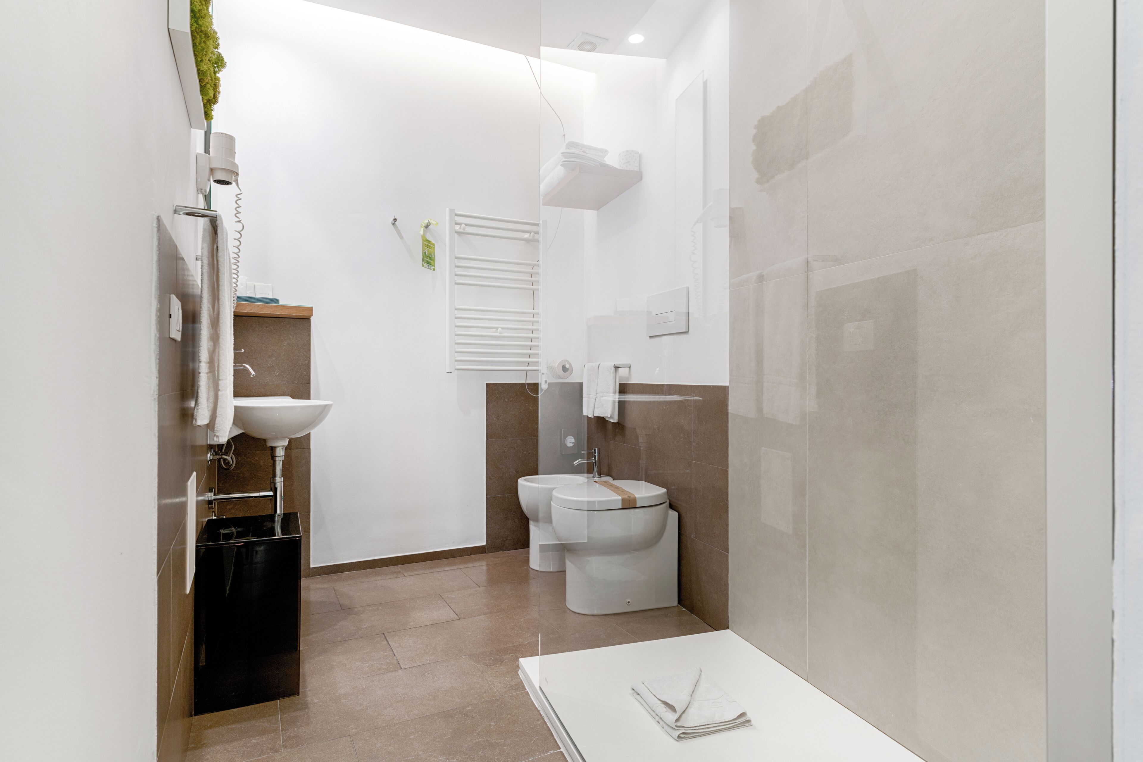 Un baño moderno con lavamanos, inodoro y bañera blancos.