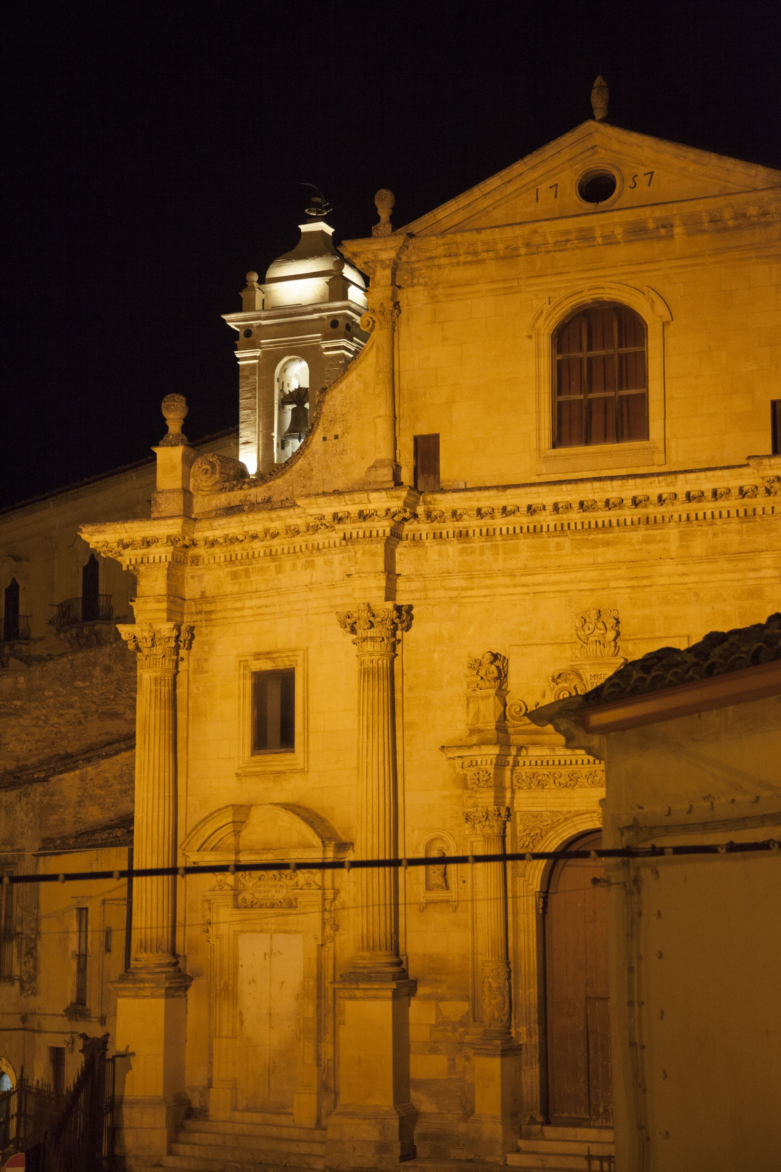 A historic building with a bell tower, arched windows, and classical columns.